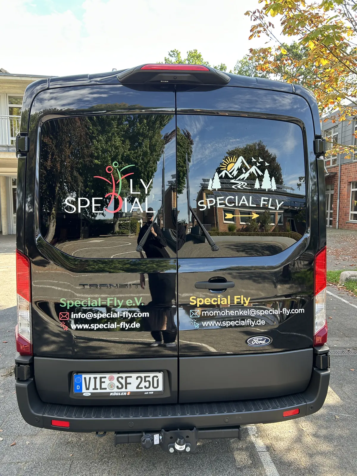 Heckbeschriftung des Ford Transit von Special Fly mit Logos und Kontaktdaten