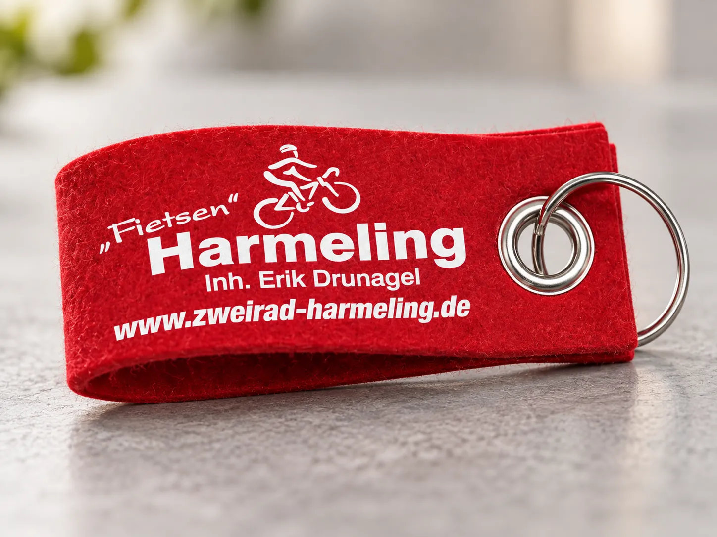 Detailaufnahme eines roten Filz-Schlüsselanhängers von Zweirad Harmeling